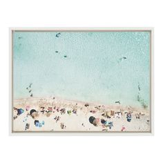 an aerial view of a beach with people and umbrellas on the sand, in front of blue water