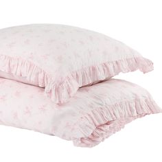 two pillows with ruffles on them sitting next to each other