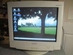 an old computer monitor is turned on with the image of a park in the background