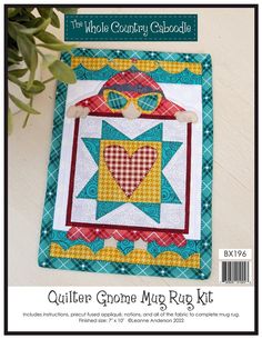 the quilter's corner mug rug kit is displayed on a table with green leaves