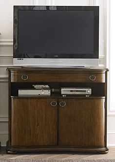 a flat screen tv sitting on top of a wooden cabinet