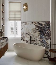 a bath tub sitting next to a window in a bathroom