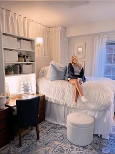 a woman sitting on top of a bed in a bedroom