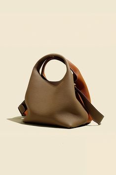 European Elegance Woven into Every Stitch: Timeless Style for 2024 This boutique-designed genuine leather bucket bag embodies the essence of European fashion. Crafted from high-quality soft calfskin, it ensures a delicate touch combined with lasting durability. The bag's unique cylindrical shape, paired with meticulous stitching, renders a style that's both vintage and contemporary. In terms of color, options range from classic black, grey melded with reddish-brown, cream combined with red, to d Luxury Modern Textured Leather Bucket Bag, Unique Handbags Fashion Bags, Modern Textured Leather Double Handle Bucket Bag, Trend Bag 2024, Bag Product Photography, 2024 Bag Trends, Bag Trends 2024, Designer Leather-lined Bucket Bag, Bag Photography