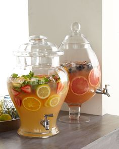 two large pitchers filled with drinks sitting on top of a table