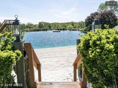 a wooden walkway leading to a lake with boats in the water