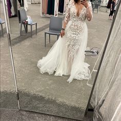 a woman taking a selfie in front of a mirror wearing a wedding dress and holding a cell phone