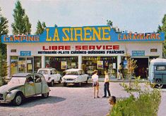 people are standing in front of a car dealership with cars parked outside the building