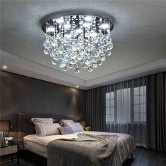 a bedroom with a large bed and a chandelier hanging from the ceiling above it