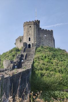 an old stone castle sitting on top of a hill