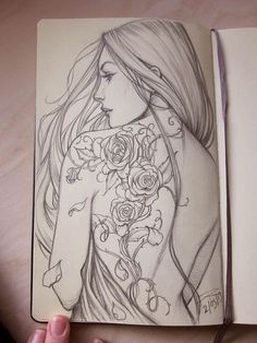 a drawing of a woman's back with roses on her arm and shoulder, in a notebook