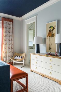 a living room filled with furniture and two lamps on top of dressers in front of a window