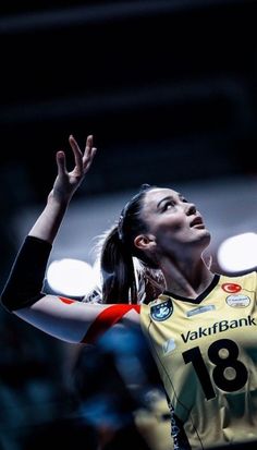 a female volleyball player is reaching up to hit the ball with her racket in mid air