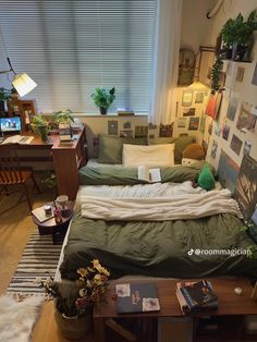 an unmade bed in a small room with lots of pictures on the wall and floor