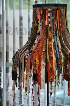 a lamp shade made out of scarves and ribbons