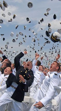 a group of men in naval uniforms throwing caps into the air