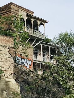 an old brick building with graffiti on the side and balcony balconies above it