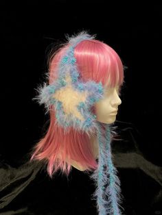 a mannequin head with pink hair and blue feathers