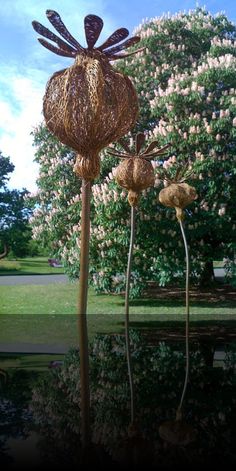 two metal sculptures in the shape of flowers