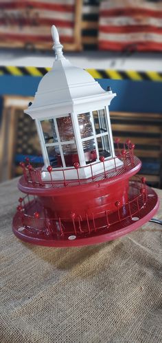 a red and white lighthouse sitting on top of a table