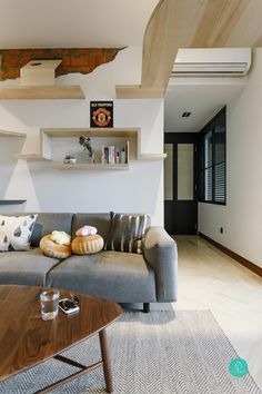 a living room filled with furniture next to a wooden table and bookshelf on the wall