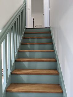 a set of wooden stairs leading up to a white door