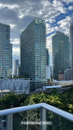 some very tall buildings in the city under a cloudy sky