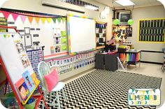 a classroom with black and white flooring and colorful decorations on the walls, desks and chairs