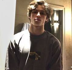 a young man standing in front of a bathroom mirror