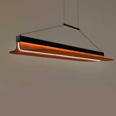 a suspended light fixture with an orange and black strip hanging from it's side