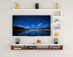 a flat screen tv mounted on a wall with shelves above it and bookshelves below