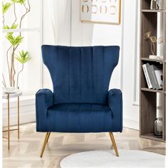 a living room with a blue chair and bookshelf in the corner, next to a white rug