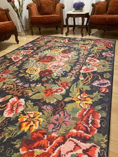 a living room with two chairs and a rug on the floor in front of it