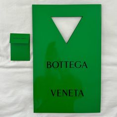 there is a green sign that says bottega veneta next to it