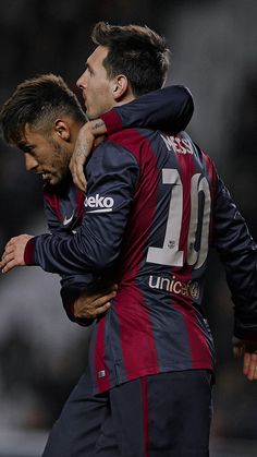 two soccer players are hugging each other on the field