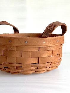 a wooden basket sitting on top of a white table