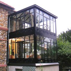 a large glass house sitting on the side of a building