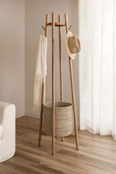 a wooden coat rack with two hats and a scarf hanging from it's sides