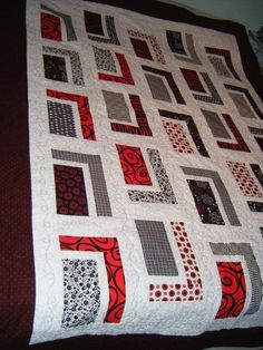 a red and black quilt on a bed