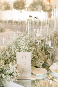 the table is set with white plates and silverware, flowers in vases, and napkins