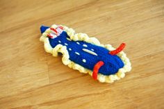 a crocheted toy airplane sitting on top of a wooden table