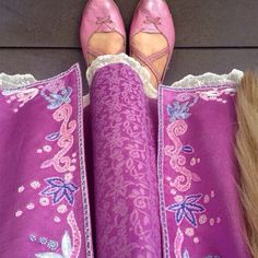 a woman's feet wearing pink shoes and purple dress with white lace on them