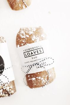 two loaves are sitting next to each other on a white surface with black and white tags