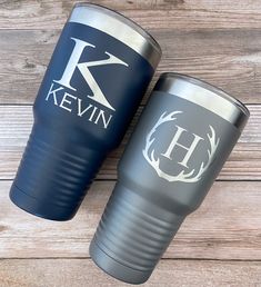 two personalized tumblers sitting next to each other on a wooden surface with the initials k and kevin