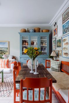 the dining room table is surrounded by colorful chairs and pictures on the wall above it