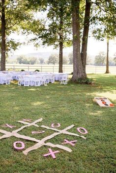 an outdoor wedding ceremony setup with pink ribbon and scissors on the grass in front of trees