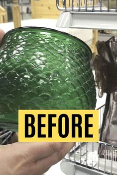 a person holding a green glass in front of an open dishwasher