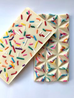 two pieces of white chocolate with sprinkles on them