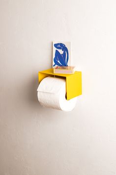 a yellow shelf with two rolls of toilet paper on it