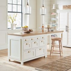 a kitchen island with two stools in front of it and an area rug on the floor